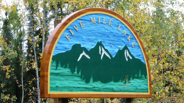 Anfahrt zum  Five Mile Lake Campground / Mayo / Silver Trail  Etwa einen Kilometer nördlich von Stewart Crossing quert man den Stewart River. Unmittelbar nach der Brücke muss man sich entscheiden ob man weiter auf dem Klondike Hyw. bleibt oder nach rechts abbiegt, um dem SILVER TRAIL bis Mayo bzw. Keno zu folgen.  Am 28.08.12 entschieden wir uns für den SILVER TRAIL (Hyw.# 11). Im wesentlichen folgt die geteerte Straße dem Stewart River bis Mayo (50km). Immer wieder hat man schöne Sicht auf den mäanderten Fluss und auf die südlich gelegenen Höhenzüge.  Erreicht man das verschlafe Nest Mayo, sind es noch 7km Richtung Keno bis man den in einem Waldgebiet gelegenen Campground erreicht.   Die 20 großzügig geschnittenen Sites mit Bank, Tisch und Feuerring, einige davon direkt am Lake, werden durch Nadelbäume von der Nachbarsite getrennt und man hat dadurch keinen Sichtkontakt zum Nachbarn.   Der ruhige, mitten im Nirgendwo liegende staatliche CG, hat nur Pit-Toiletten und Pumpenwasser, aber kostenloses Feuerholz.   Einige Trails, einer davon rund um den See, beginnen auf dem Campground.  Uns hat die Lage und der Campground außerordentlich gut gefallen.